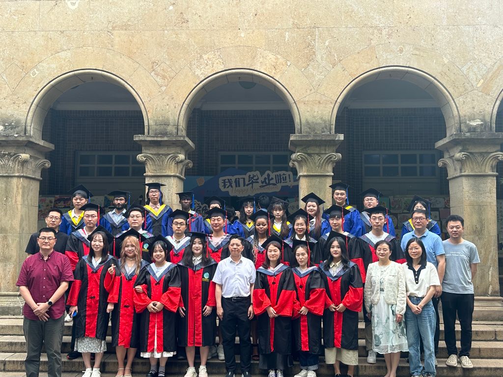 Large MSc cohort photograph under arched stone entrance