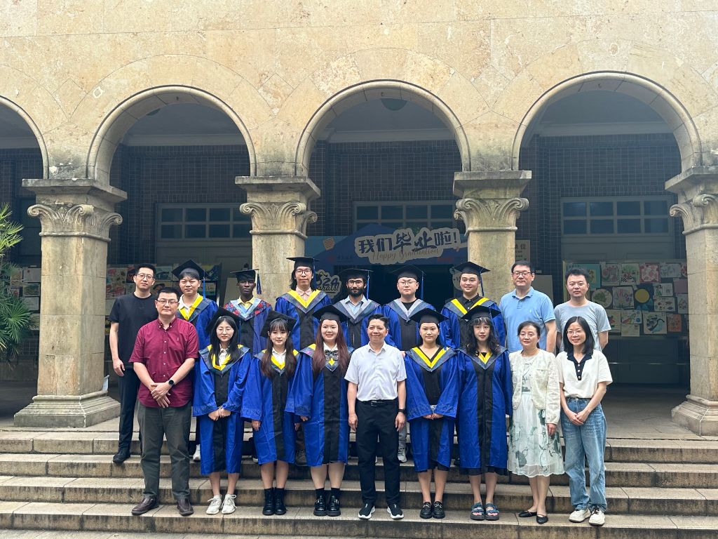Formal group photograph with lab supervisors and cohort members on graduation steps